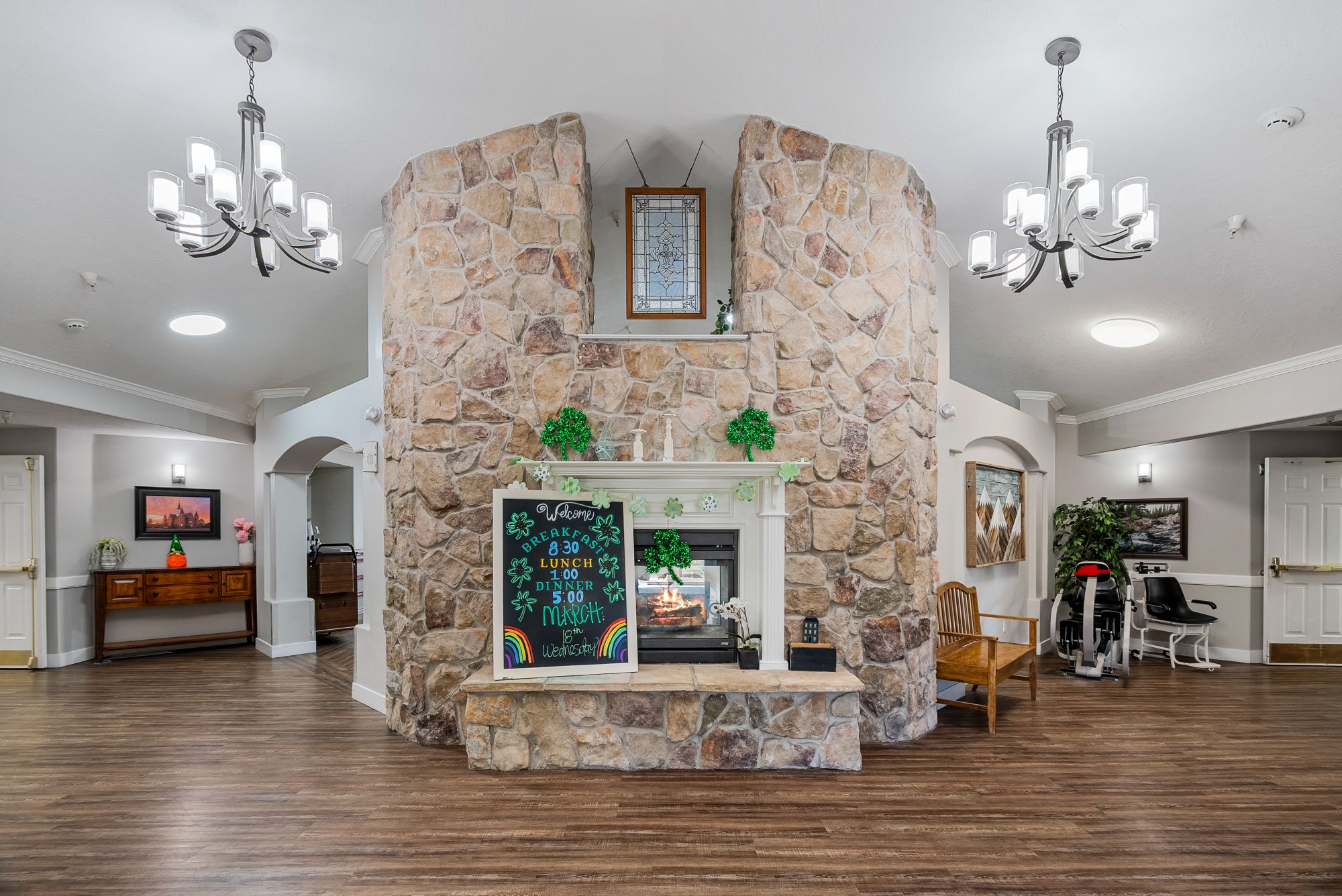 Grand stone fireplace and chandeliers in the Hearthstone Manor lobby